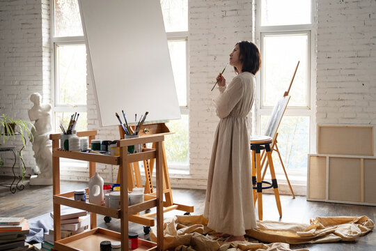 Young female painter painting in a studio