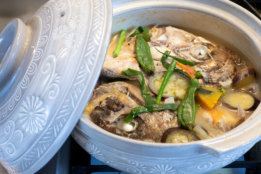 Fish head stew in a ceramic pot. Sinabawang ulo ng isda. 