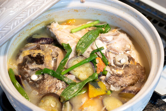 Fish head stew in a ceramic pot. Sinabawang ulo ng isda. 
