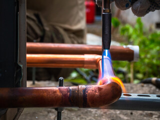 worker soldering a copper pipe