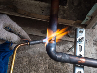 worker soldering a copper pipe