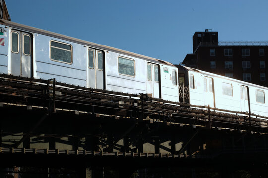 New York City elevated subway train reflecting bright morning sunshine