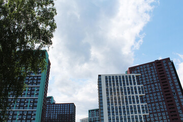 modern buildings in the city of Kyiv, Ukraine with green trees on a blue sky background. clouds over the city. 