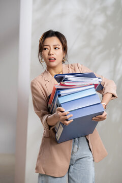 Young professional women carrying a stack of folders