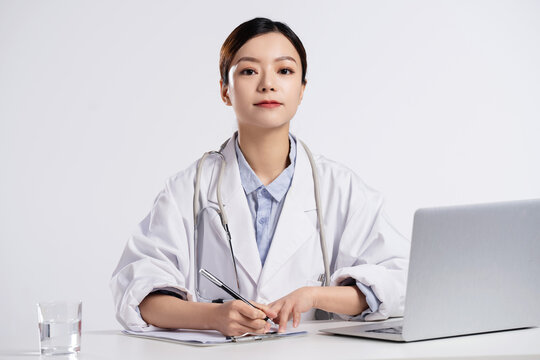 A young female doctor write medical records