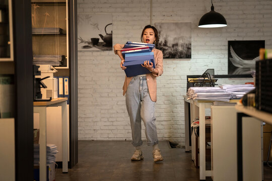 Youth career women hold a stack of folders