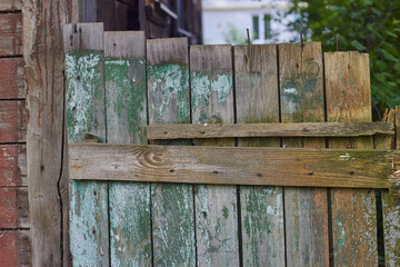 Photo of old wooden fence with faded paint.