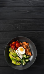 Low-carbohydrate breakfast concept. Salmon salad for ketogenic diet with avocado, cucumber, tomato and sesame on wooden background. top view. Banner.