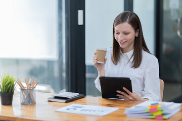 Portrait of beautiful smiling young brunette businesswoman sitting at in the office modern work station