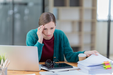 Attractive young office worker holding a  binder as she looks at the camera with a sweet friendly smile