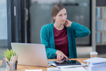 Attractive young office worker holding a  binder as she looks at the camera with a sweet friendly smile