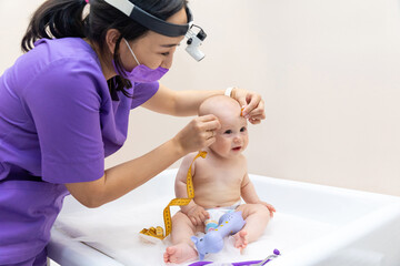 medicine, healthcare and pediatrics concept - female pediatrician doctor with measure tape...