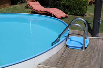 a round pool with a sun lounger in the garden