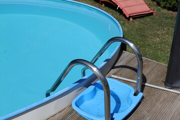 a round pool with a sun lounger in the garden