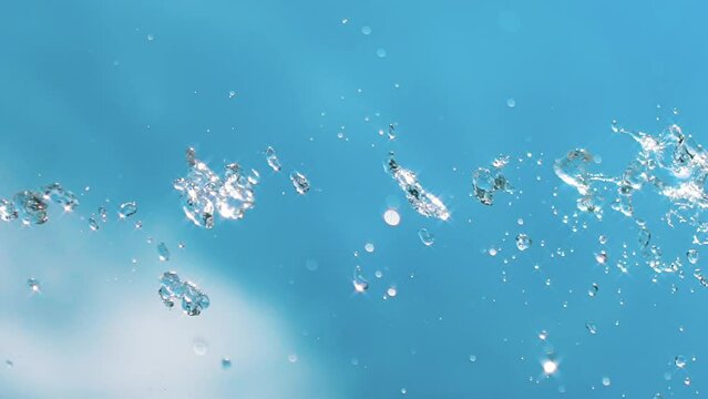 Water drips in slowmotion on a blue sky background 