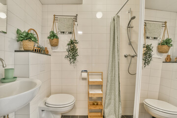 a bathroom with plants on the wall and toilet in the corner, as seen from the shower stall to the...
