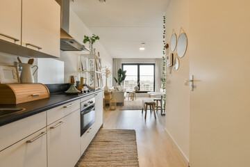 a long narrow kitchen with white cabinets and black counter tops on the floor, along with an area...
