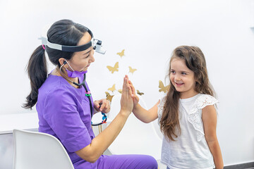 Female children's doctor gives high five to little patient after checkup in clinic encourage her before procedure, congratulate successful treatment or with good health test results