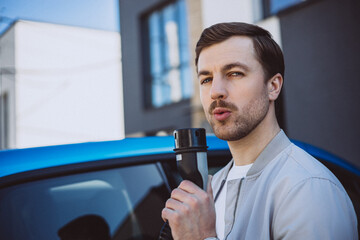 Man holding charger from electric car