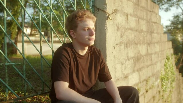 Reflecting at Sunset: Deep in Thought, Blond Young Man Sitting Outdoors