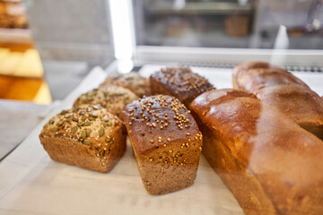 Different kinds of bread on the counter in the bakery shop. Fresh bread counter. Modern bakery with different kinds of bread, cakes and buns 