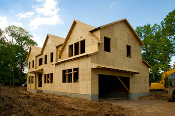 Fototapeta na wymiar Large suburban house under construction in the sheathing phase.