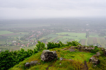 Photo with fields, agricultural buildings, houses and rain fog, it is raining