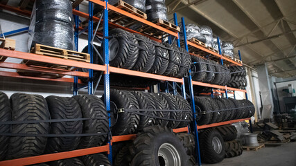 Brand new big variety of car's tyres on shelf in warehouse.
