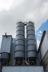 two industrial tanks against the background of gray clouds