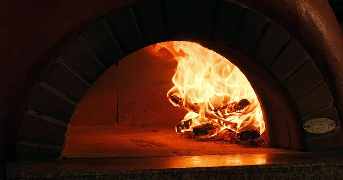 Fire wood burning in the oven. Traditional Italian pizzeria. Authentic Italian oven. The original pizza oven with flame inside
