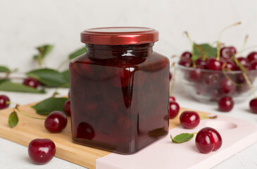 Jar with tasty homemade cherry jam on wooden table
