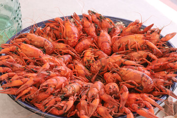 Boiled crayfish. Arranged on a large platter. Garnished with lemon slices. Close-up.