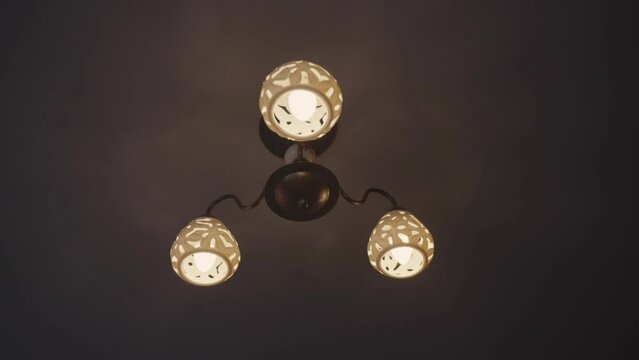 Ceiling chandelier illuminates dark premise of apartment with old renovation. Housing premise lighting. Overview of electricity model of soviet era