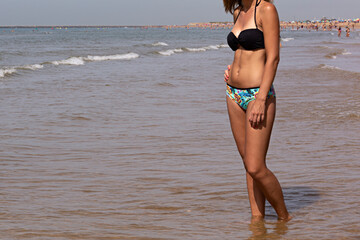 Mujer joven en blkini en la orilla del mar.
