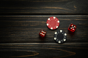 Poker chips and dice with a winning combination on a dark table. Luck in gambling depends on fortune