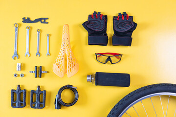 Set of different bicycle tools and parts on yellow background, flat lay. Space for text.