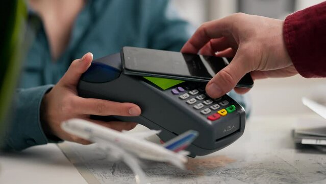 Travel agency, Experienced consultant Online payment with a smartphone terminal In the company's office Concept Aviation industry worker Works in an airline company Helps with paperwork, boarding pass