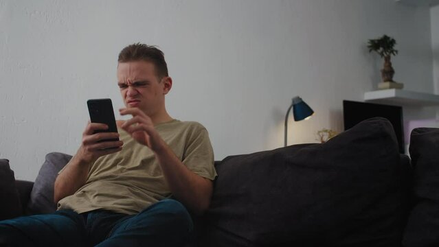 Yong Man looks at his phone with disgust, encountering negative or offensive content on social media. Concept Information Overload, Digital Dependency, Negative Content.