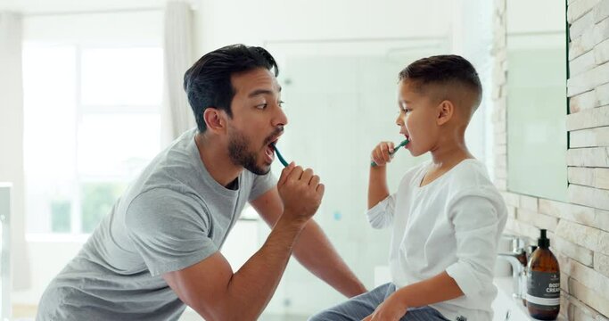 Dad, boy child and brushing teeth in bathroom for dental wellness, morning routine or teaching healthy habits. Family of father, kid and cleaning mouth with toothbrush for self care of fresh breath