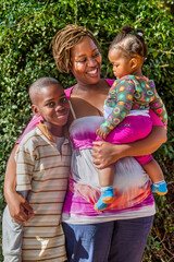 Fototapeta premium African family with single mother hugging and holding her two kids