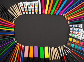 stationery items around of image on black background. Back to school background, banner with copy space. Student's or engineer's supplies. Office objects on dark background. Calculator, pencils, paint