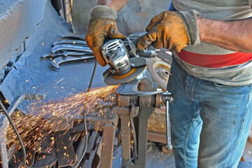 The blacksmith sharpens cutting tools.