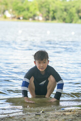 A boy playing in the water near the reservoir