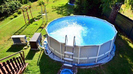 Swimming pool with metal frame for home and garden. Frame swimming pool in the yard. Garden in the...
