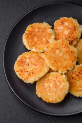 Delicious fresh cottage cheesecakes with raisins and vanilla on a black ceramic plate