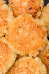 Delicious fresh cottage cheesecakes with raisins and vanilla on a black ceramic plate