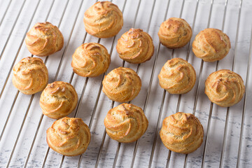Freshly baked gluten-free oatmeal profiteroles on a metal grid