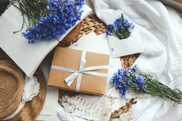 Obraz na płótnie Canvas Gift box with a bow and cornflowers, summer photo