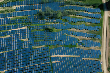 Obraz premium Solar panels plant, aerial view - rows of photovoltaic cell collectors on a landscape. Green energy concept. Generative AI
