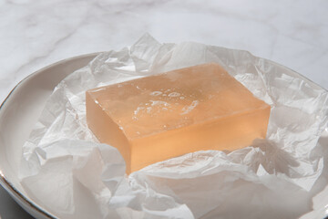 Natural bar soap for healthy skin and hair. Hydrating cleansing bar on crumpled package paper